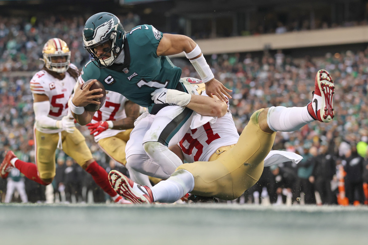 Nick Bosa wraps his arms around the waist of Jalen Hurts to sack the quarterback